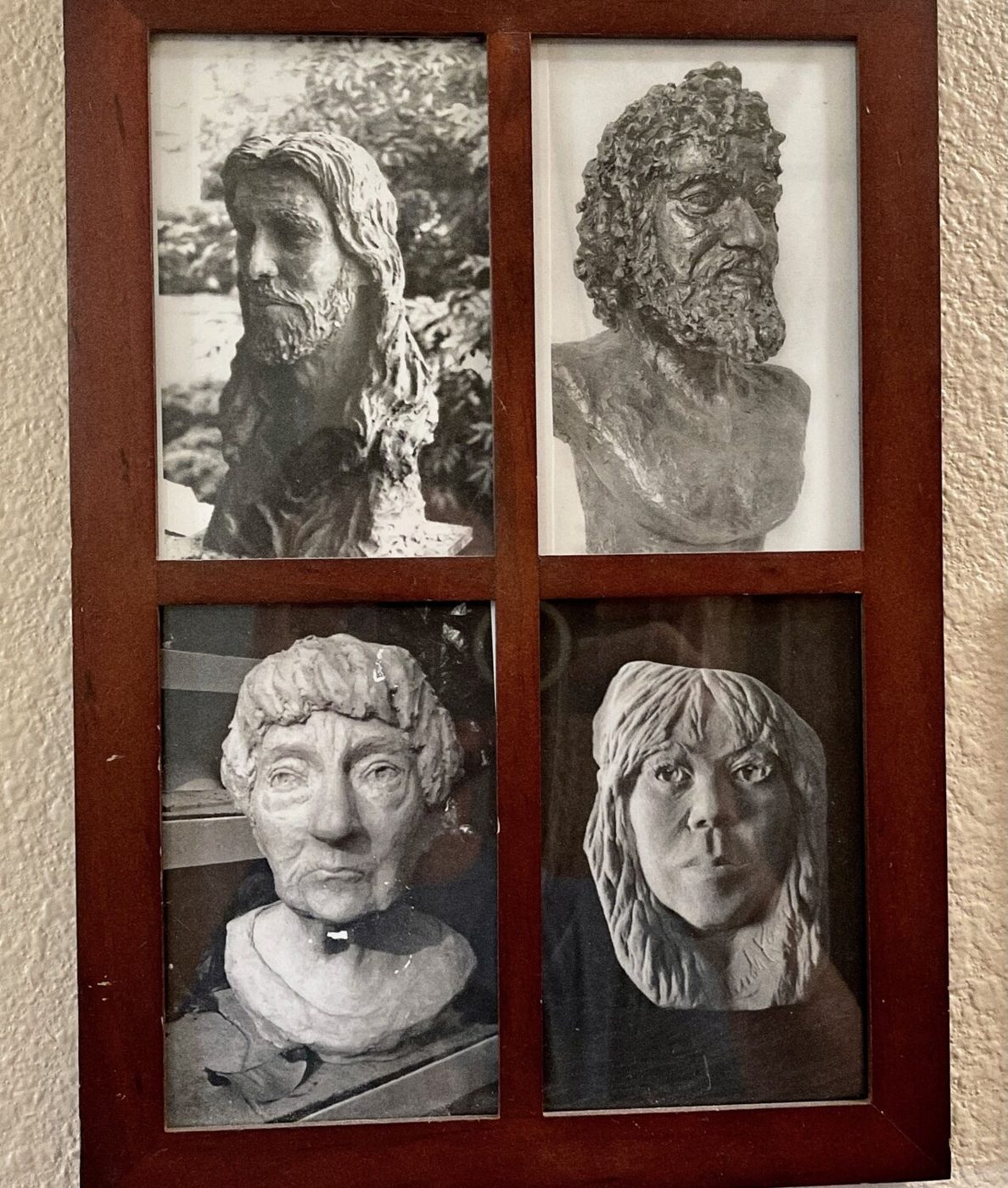 Four black and white photos of sculpted heads in one frame